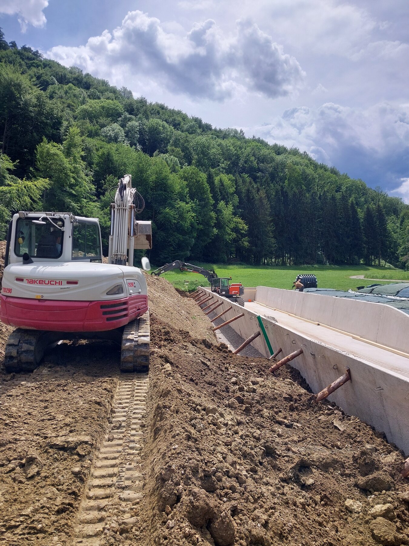 Raupenbagger der Hitzler GmbH bei Erdarbeiten auf einem größeren Baufeld