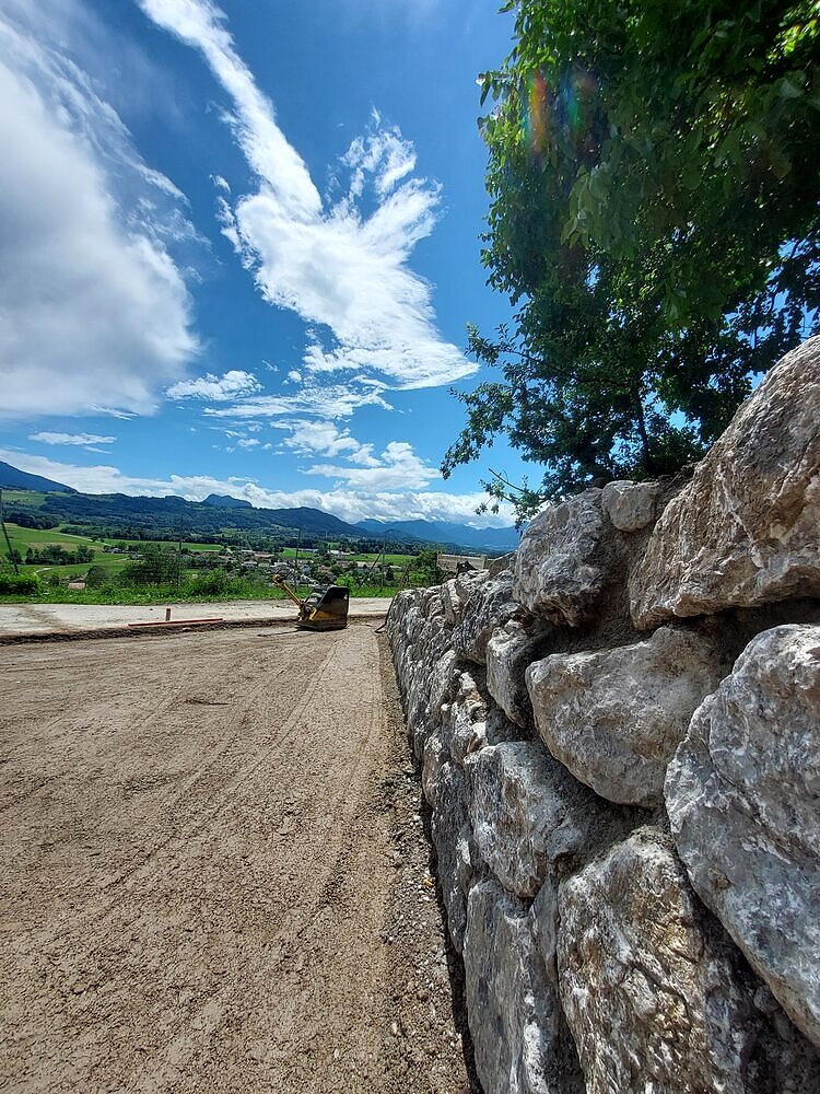 Natursteinmauer und gestaltete Außenfläche